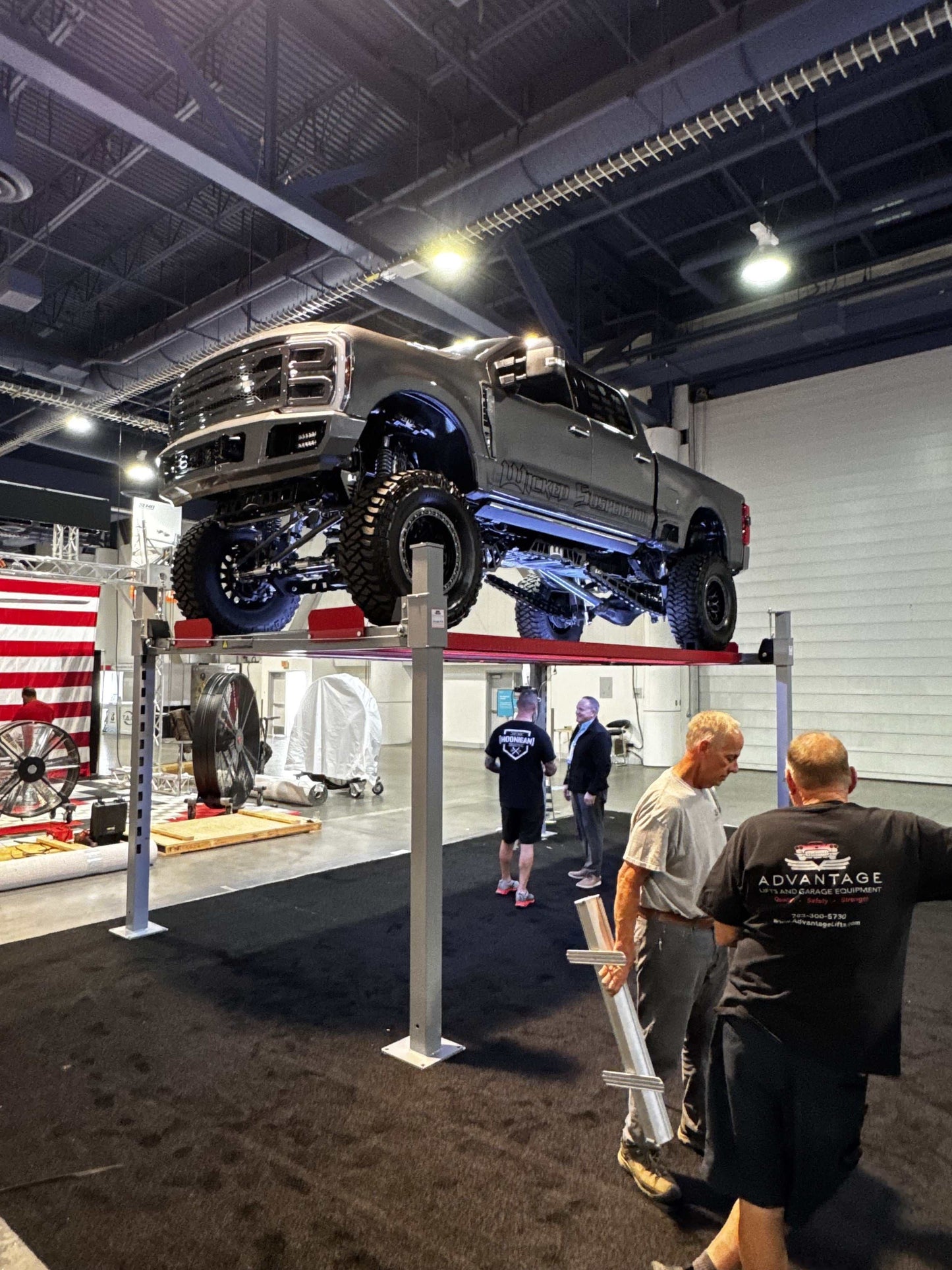 Advantage DX-11000-WD 4-post lift with 11000 lbs capacity lifting a truck in a garage setting