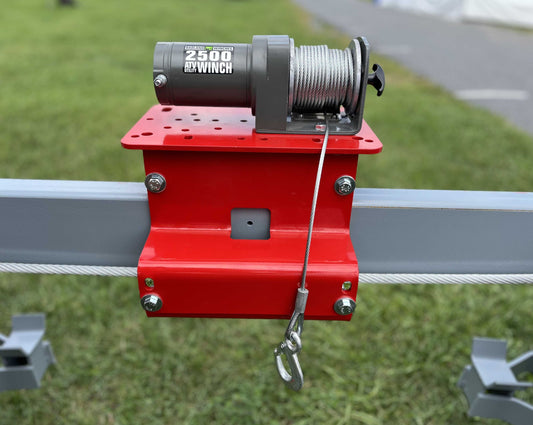Red Universal Winch Mounting Plate attached to gray 4-post lift crossmember with a 2500 lb ATV winch mounted on top