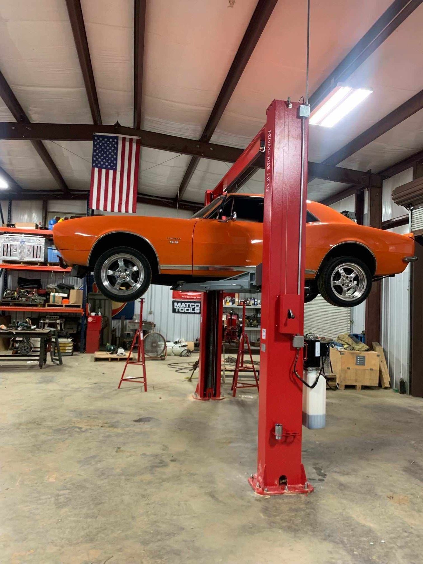 Advantage AL-12C 2-post lift with truck elevated in garage.