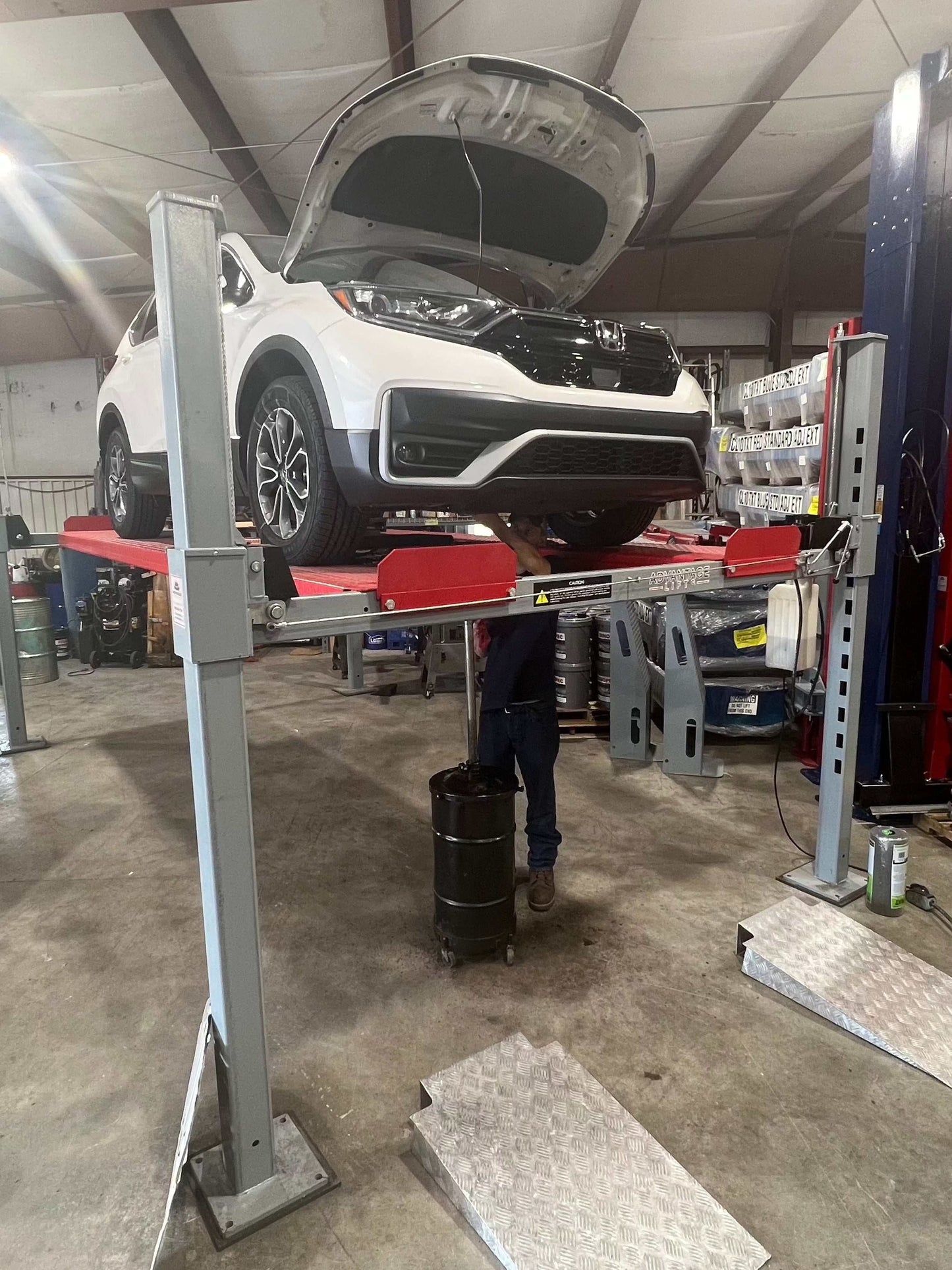 Advantage DX-11000-WD with a SUV on top and a mechanic underneath working on the car.