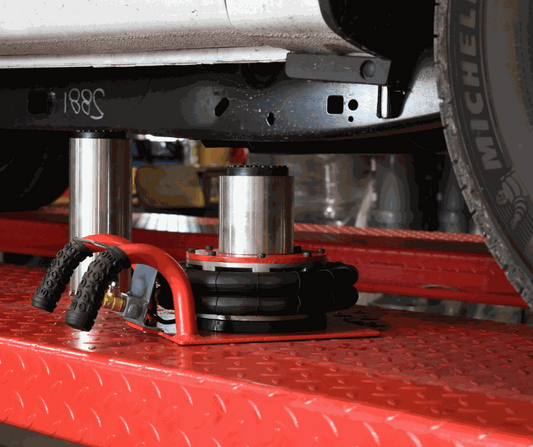 Air Bag Jack lifting low-clearance car with 2 height extensions on red platform