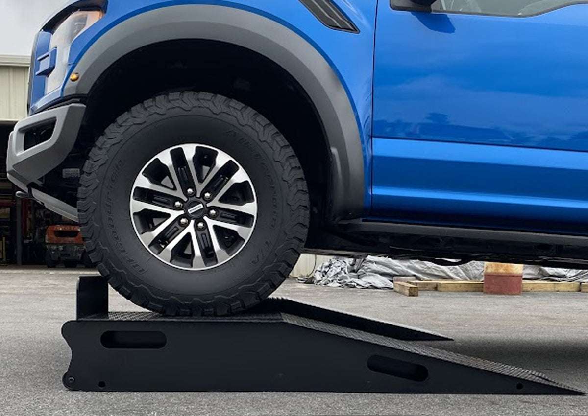 Heavy-Duty Truck Ramps from the side with a blue Ford Raptor on them