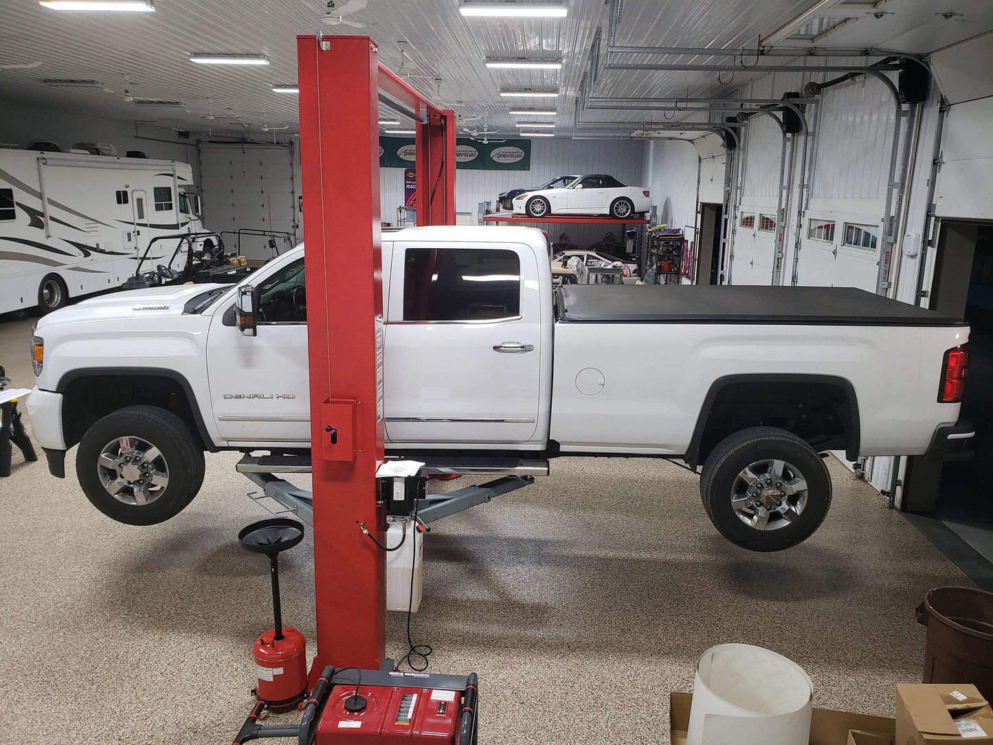 Advantage AL-12C 2-post lift with truck elevated in garage.