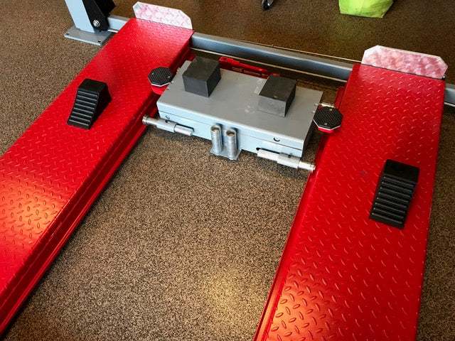 Advantage Lifts Rolling Jack (Manual) with hand pump on a 4-post lift, taken from the top down view