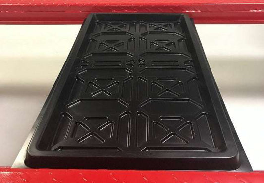 Set of 4 black plastic drip trays for catching vehicle leaks and protecting floors.