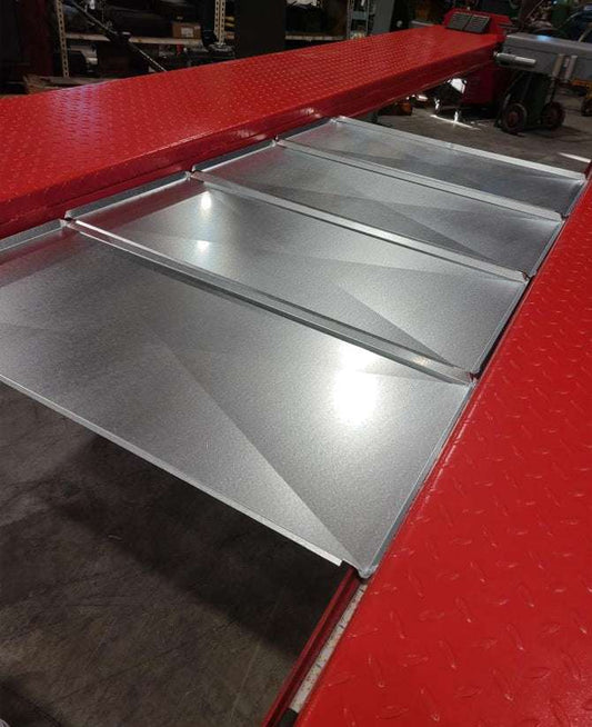 Set of 4 galvanized steel drip pans installed on red car lift platform preventing leaks with 7000 LB lift capacity