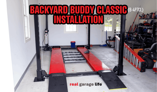 Backyard Buddy Classic car lift installed in a home garage with tools and equipment around