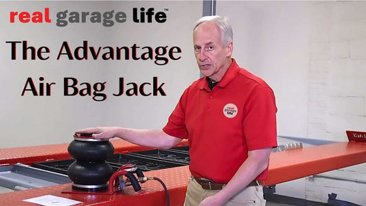 Man in red shirt demonstrating the Advantage Air Bag Jack on a car lift platform in a garage setting