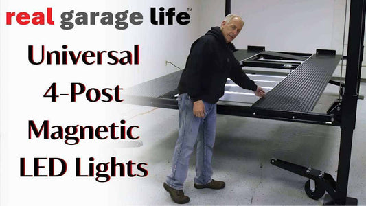 Man demonstrating Universal 4-Post Lift with magnetic LED lights in a garage setting