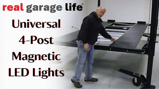 Man demonstrating Universal 4-Post Lift with magnetic LED lights in a garage setting